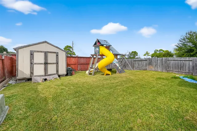 a view of a house with a backyard and a tree