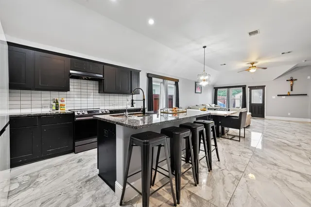 a kitchen with a sink and chairs