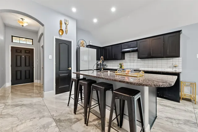 a kitchen with stainless steel appliances granite countertop a sink and a refrigerator