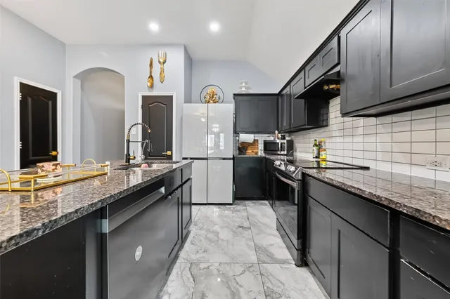 a kitchen with granite countertop a sink stove and cabinets