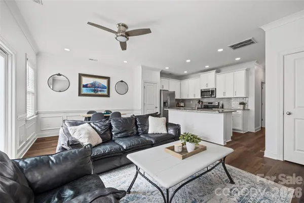 a living room with furniture kitchen view and a window