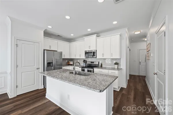 a kitchen with stainless steel appliances granite countertop a sink stove and refrigerator