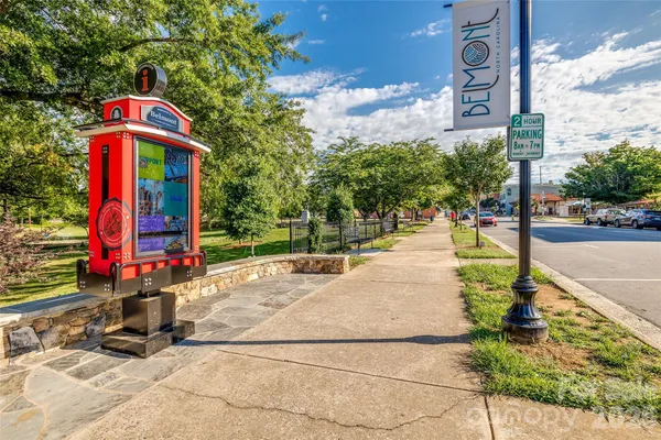 a front view of multi story residential apartment building with yard and sign board