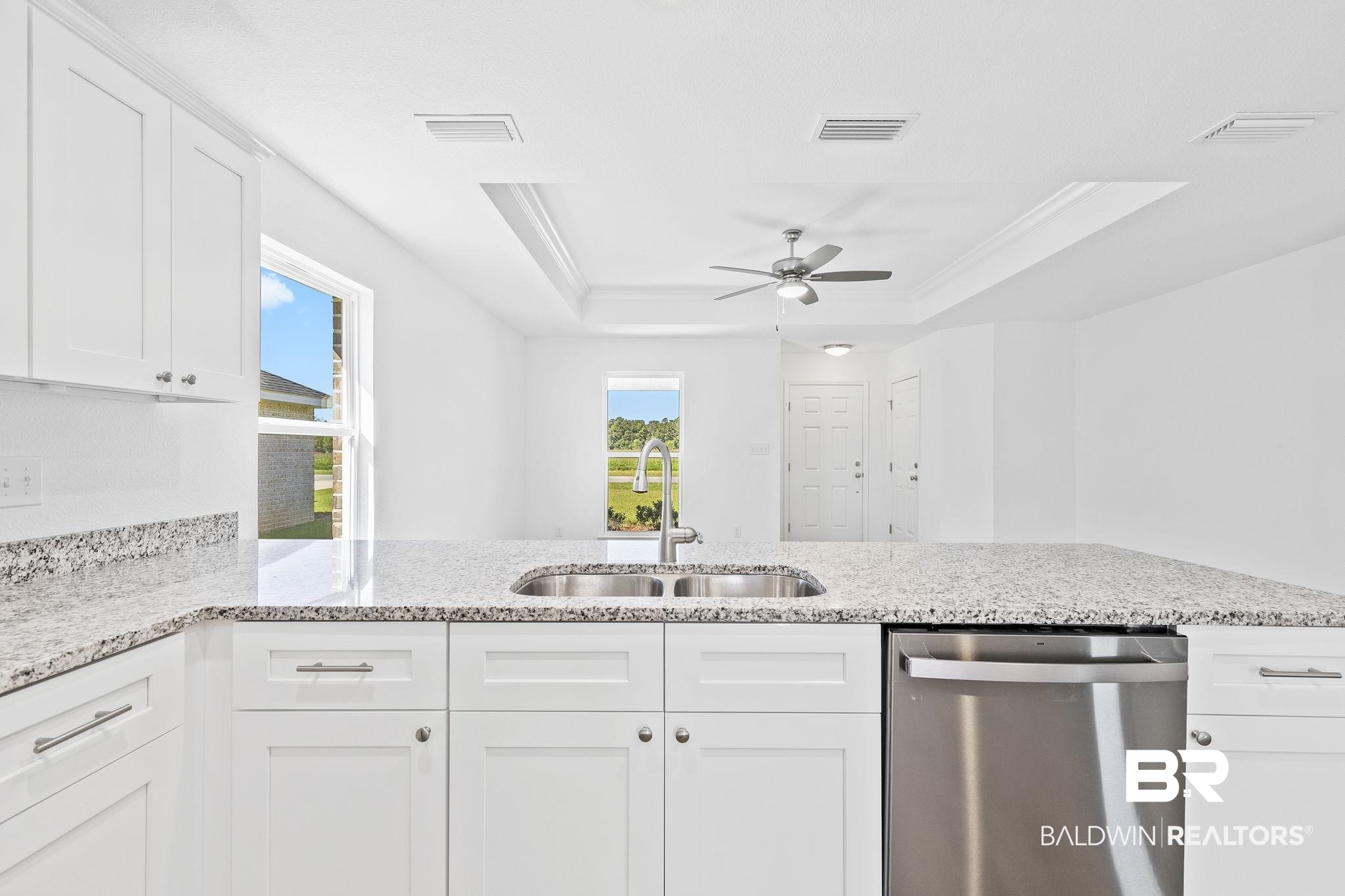 16014 Alabama Avenue Silverhill, AL 36576 - Photo 15 of 50 Kitchen with ceiling fan, a raised ceiling, sink, white cabinets, and stainless steel dishwasher