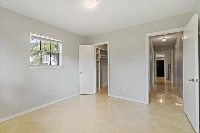 an empty room with windows and closet
