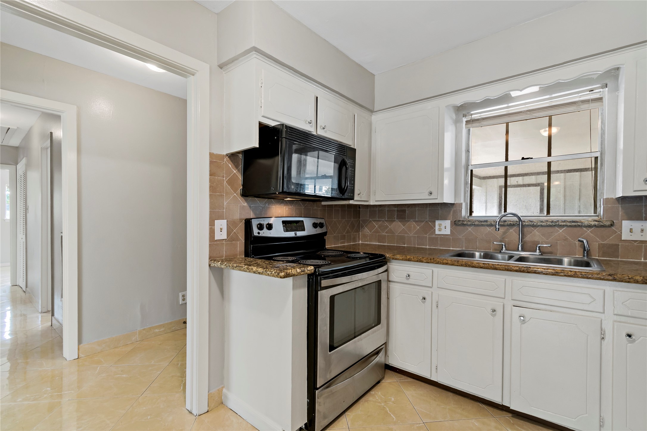 1522 Baggett Lane, Unit A Houston, TX 77055 - Photo 5 of 29 a kitchen with stainless steel appliances granite countertop a stove a sink and a microwave