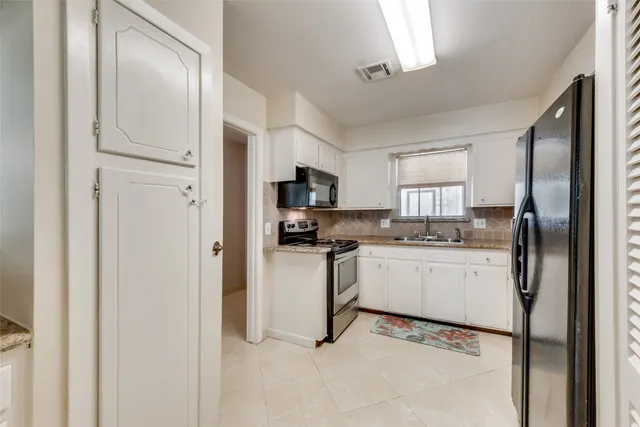 a kitchen with white cabinets and stainless steel appliances