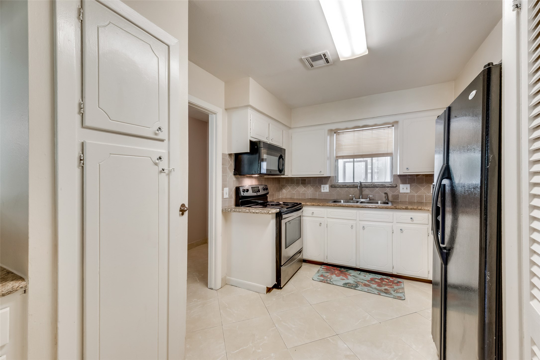 1522 Baggett Lane, Unit A Houston, TX 77055 - Photo 6 of 29 a kitchen with white cabinets and stainless steel appliances