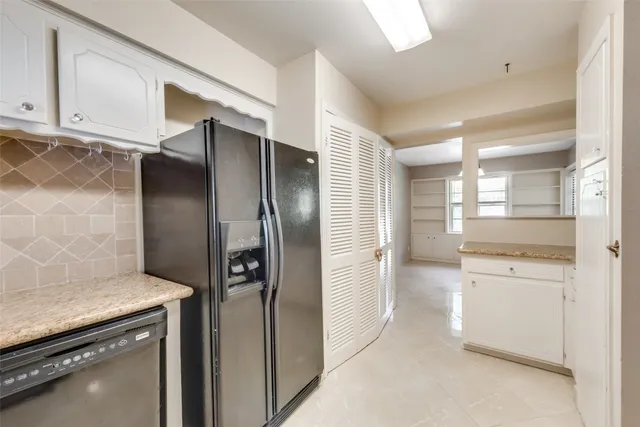 a kitchen with stainless steel appliances granite countertop a refrigerator and a stove
