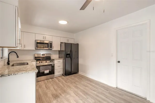 a kitchen with stainless steel appliances granite countertop a refrigerator a stove top oven a sink and dishwasher