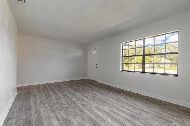wooden floor in an empty room with a window