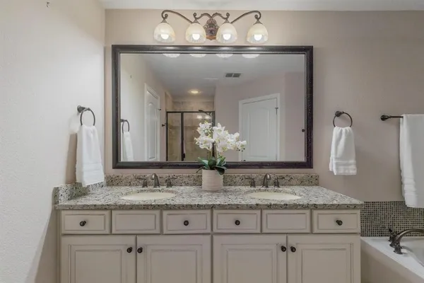a bathroom with a granite countertop sink and a mirror