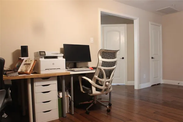 a view of a workspace with furniture and wooden floor