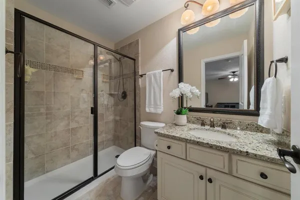 a bathroom with a granite countertop sink toilet and shower