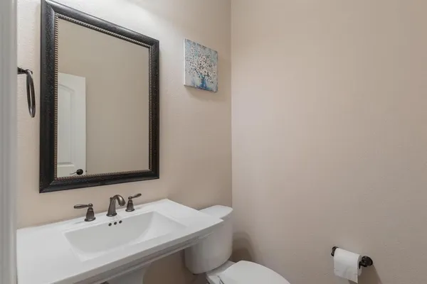 a bathroom with a sink mirror and toilet