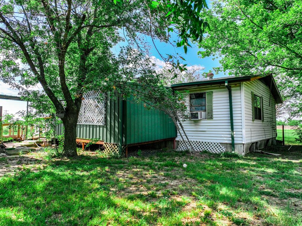 7801 West Interstate Highway Cumby, TX 75433 - Photo 8 of 31 a view of a backyard with a small cabin and entertaining space