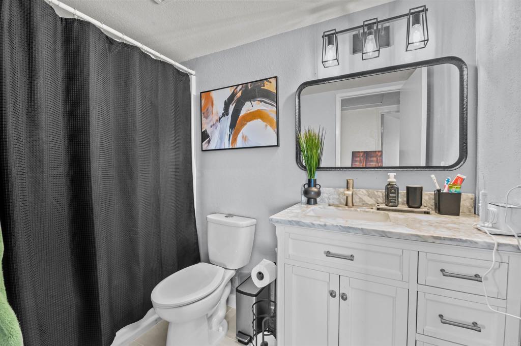 772 Barsby Street Vista, CA 92084 - Photo 15 of 28 a bathroom with a granite countertop toilet sink and mirror