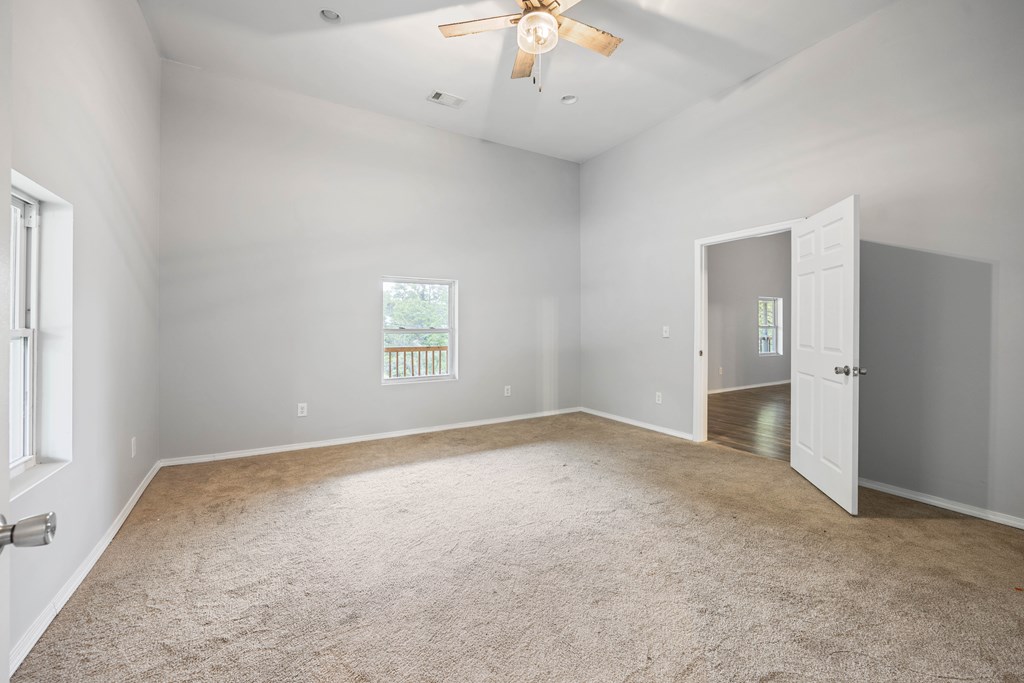 2113 Summerville Road Phenix City, AL 36867 - Photo 26 of 37 an empty room with a chandelier fan and windows