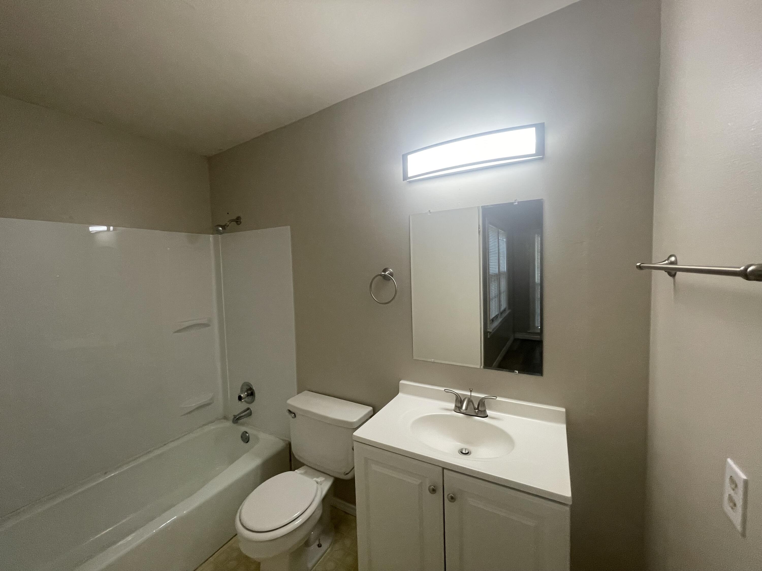 2820 36th Street Lubbock, TX 79413 - Photo 11 of 11 a bathroom with a toilet a sink a mirror and shower