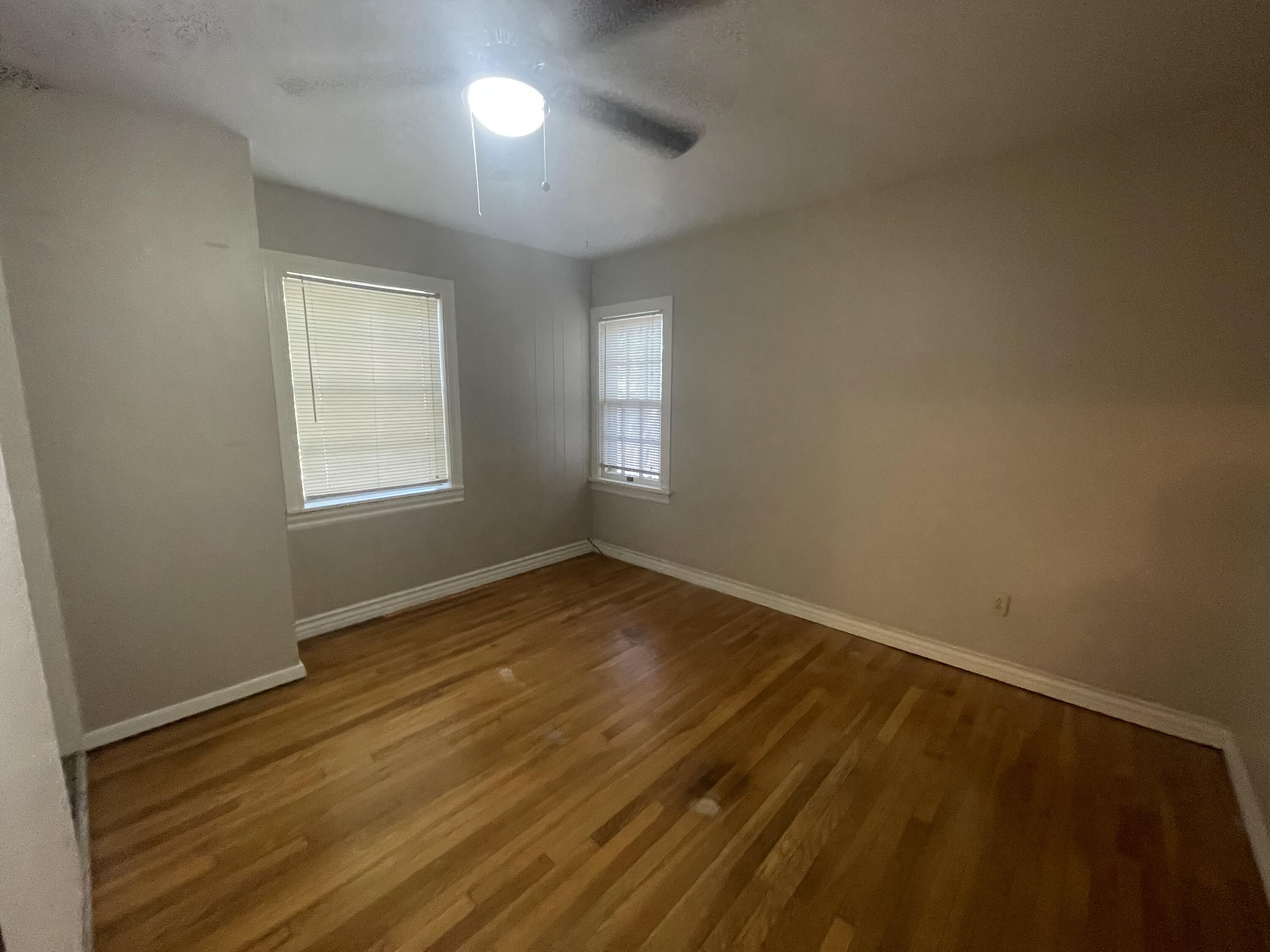 2820 36th Street Lubbock, TX 79413 - Photo 7 of 11 an empty room with wooden floor and windows