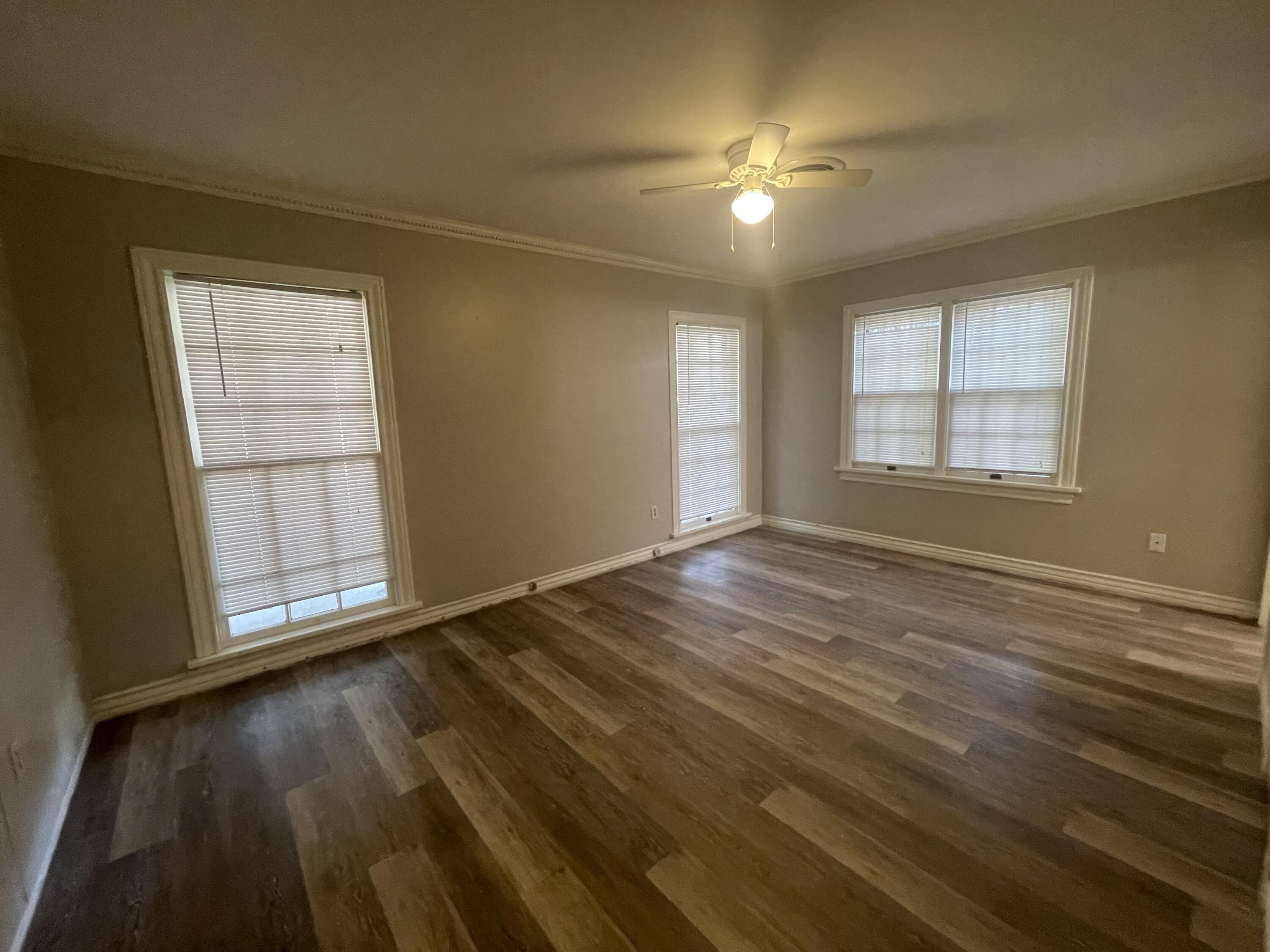 2820 36th Street Lubbock, TX 79413 - Photo 10 of 11 an empty room with wooden floor and windows