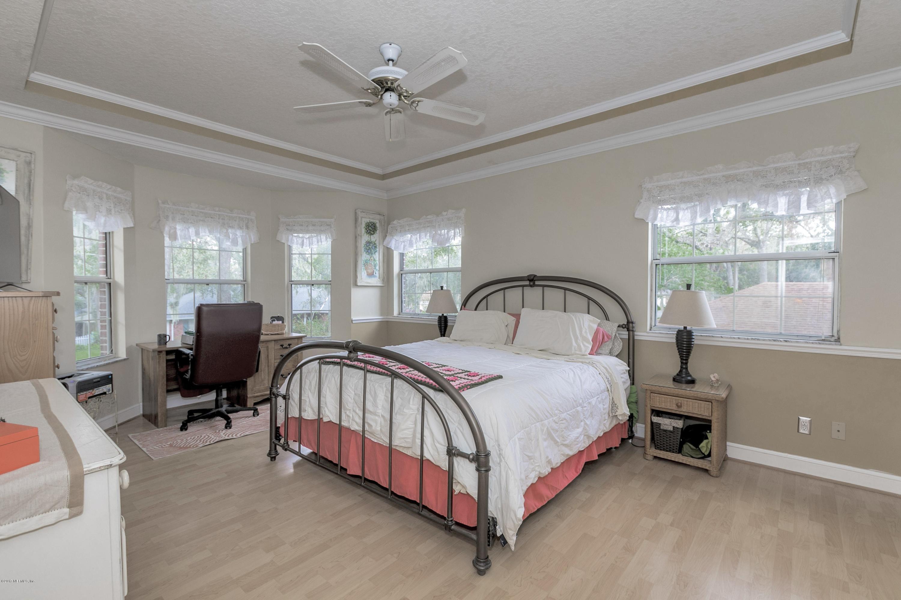 3301 Turtle Creek Road St. Augustine, FL 32086 - Photo 11 of 26 a bedroom with a bed flat screen tv and windows