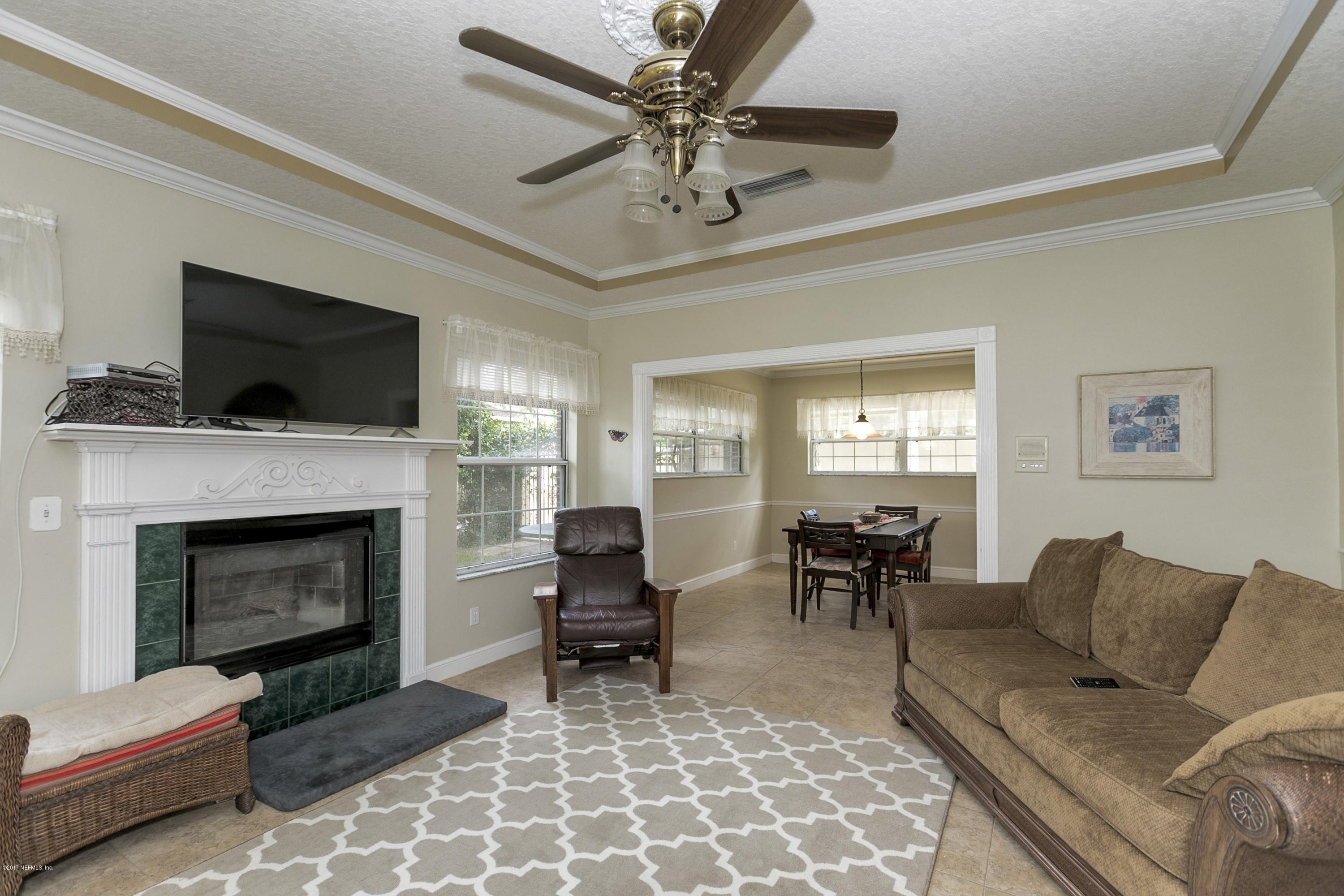 3301 Turtle Creek Road St. Augustine, FL 32086 - Photo 4 of 26 a living room with furniture a flat screen tv and a fireplace
