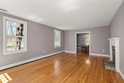 a view of an empty room with a window and a kitchen