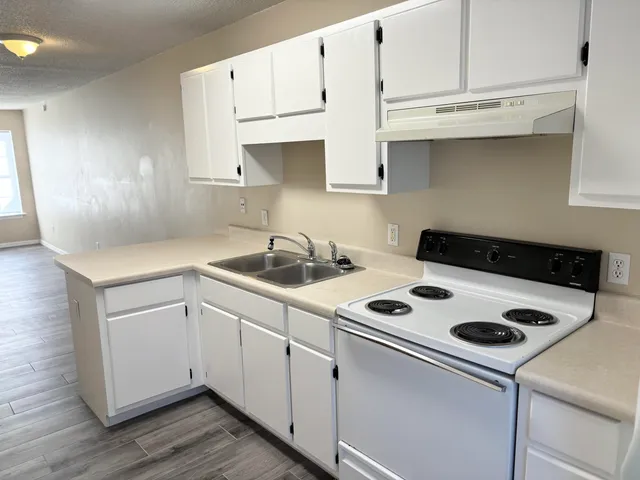 a kitchen with white cabinets and white appliances