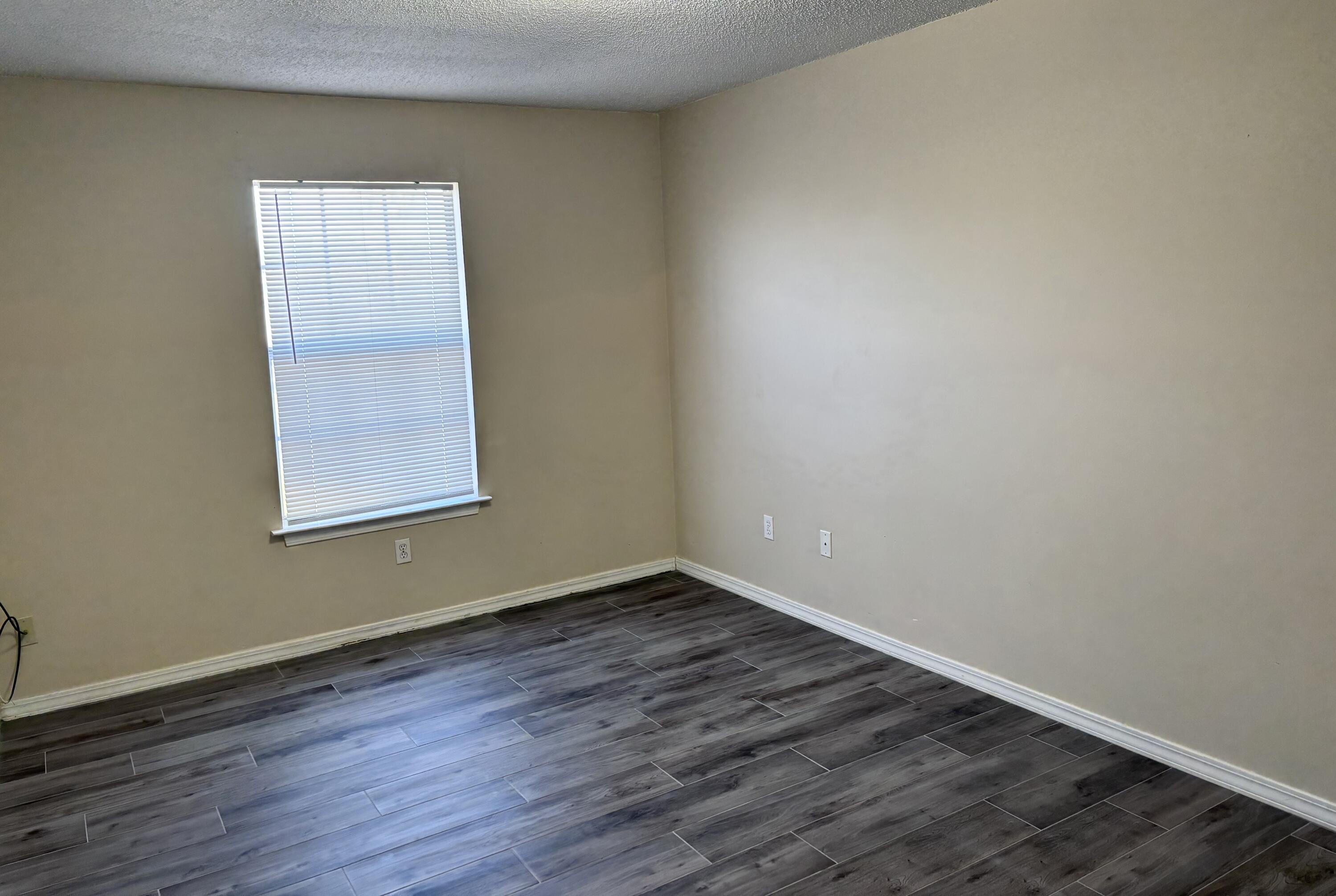 6903 Sea Turtle Circle, Unit B Navarre, FL 32566 - Photo 6 of 10 an empty room with wooden floor and windows