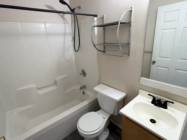 a white toilet sitting next to a bath tub