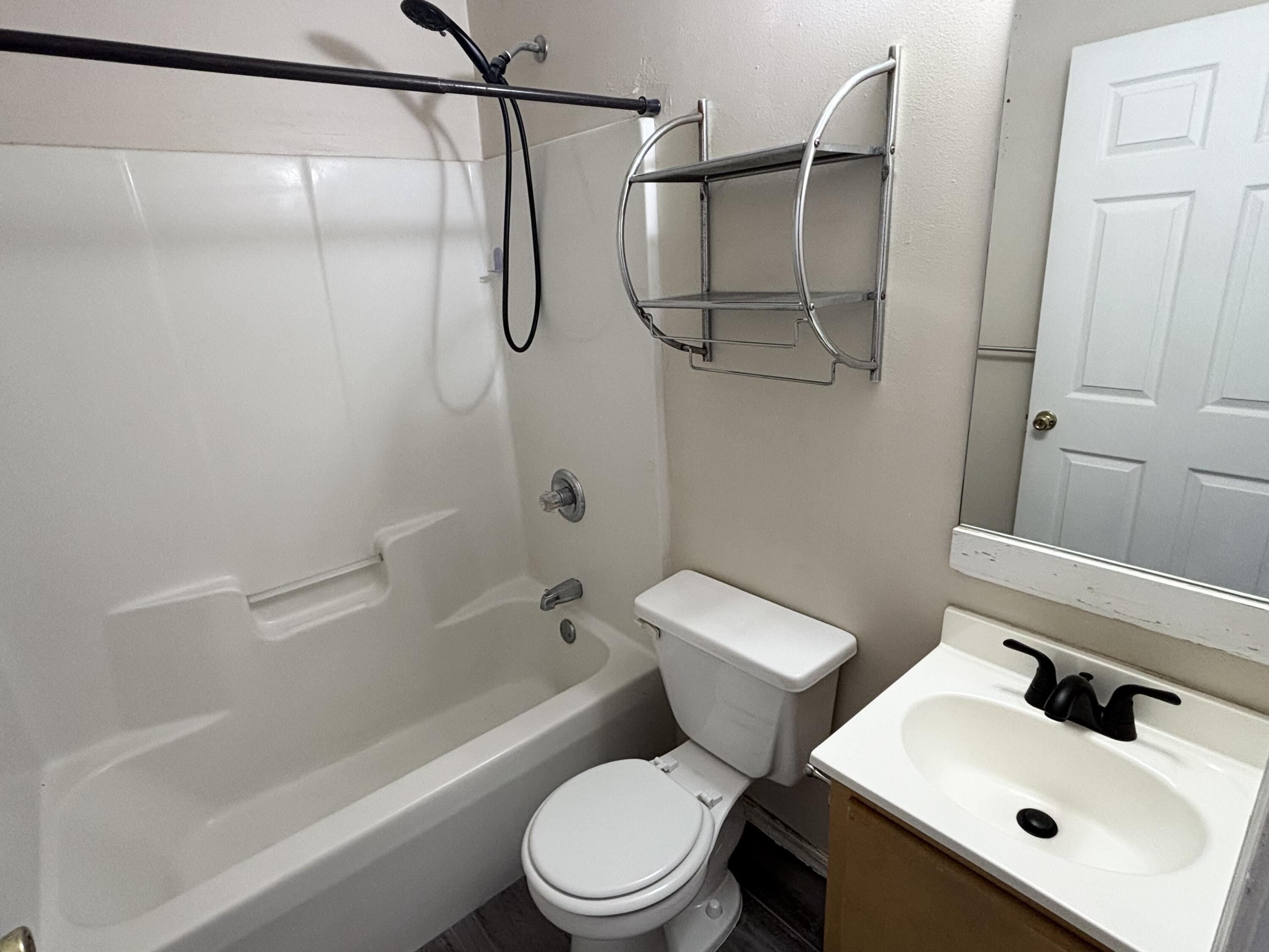 6903 Sea Turtle Circle, Unit B Navarre, FL 32566 - Photo 7 of 10 a white toilet sitting next to a bath tub