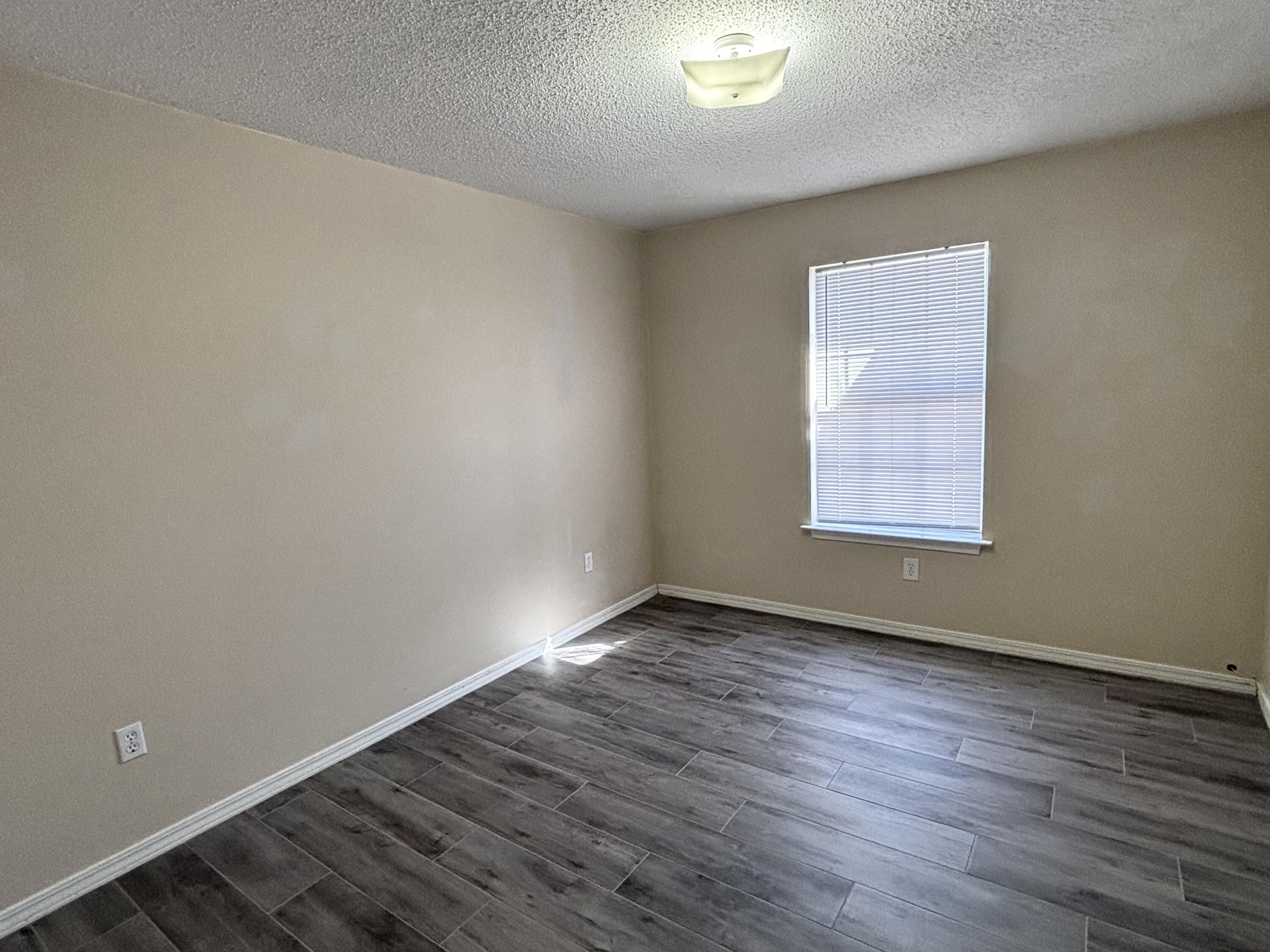 6903 Sea Turtle Circle, Unit B Navarre, FL 32566 - Photo 8 of 10 an empty room with wooden floor and windows