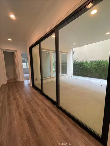 a view of hallway with a large window and wooden floor