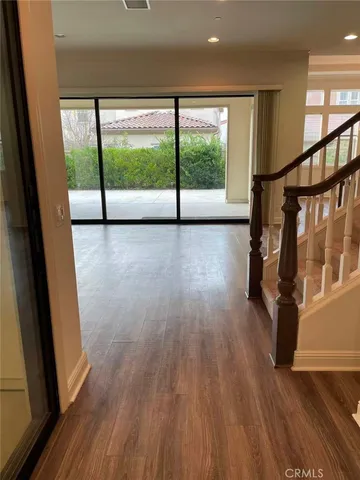 a view of hallway with wooden floor and door
