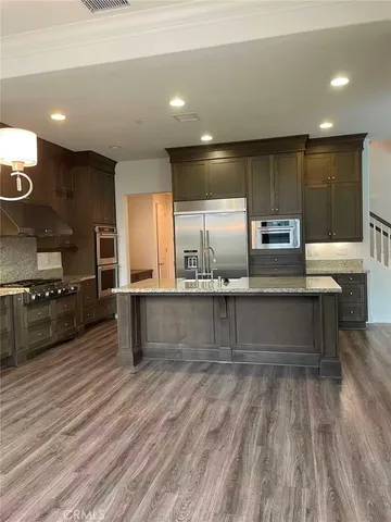 a large kitchen with a large counter top stainless steel appliances and cabinets