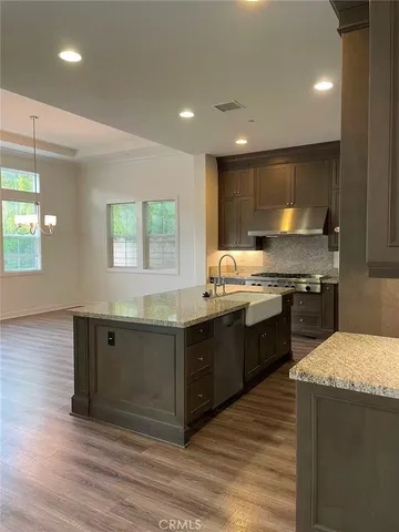 a kitchen with stainless steel appliances granite countertop a stove a sink and a microwave