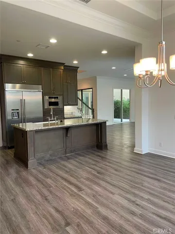 a large kitchen with stainless steel appliances kitchen island a large counter top and a wooden floors