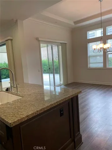 a kitchen with granite countertop a sink a window and wooden floor