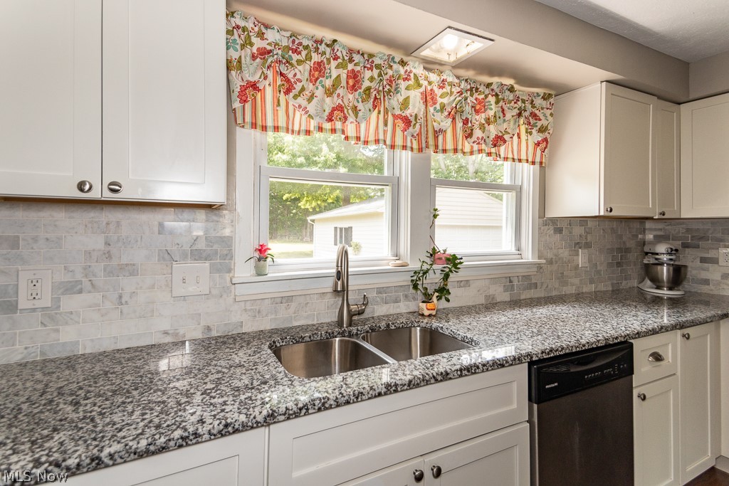38488 Bell Road Willoughby, OH 44094 - Photo 7 of 22 Kitchen featuring tasteful backsplash, white cabinets, sink, stainless steel dishwasher, and stone countertops