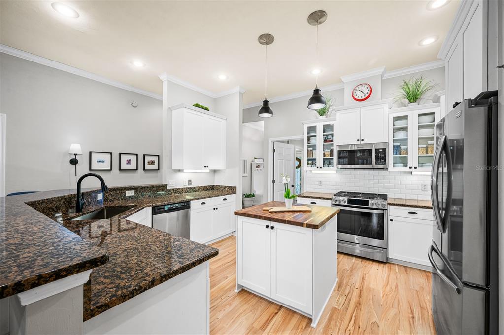 6377 Southwest 88th Terrace Gainesville, FL 32608 - Photo 12 of 37 a kitchen with stainless steel appliances granite countertop a sink stove and refrigerator