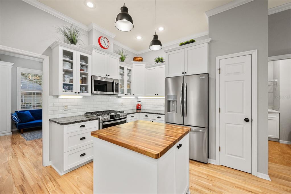 6377 Southwest 88th Terrace Gainesville, FL 32608 - Photo 13 of 37 a kitchen with a stove a refrigerator a oven a sink and dishwasher with wooden floor