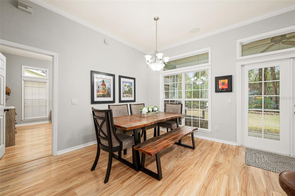 6377 Southwest 88th Terrace Gainesville, FL 32608 - Photo 15 of 37 a dining room with wooden floor a chandelier a wooden table and chairs