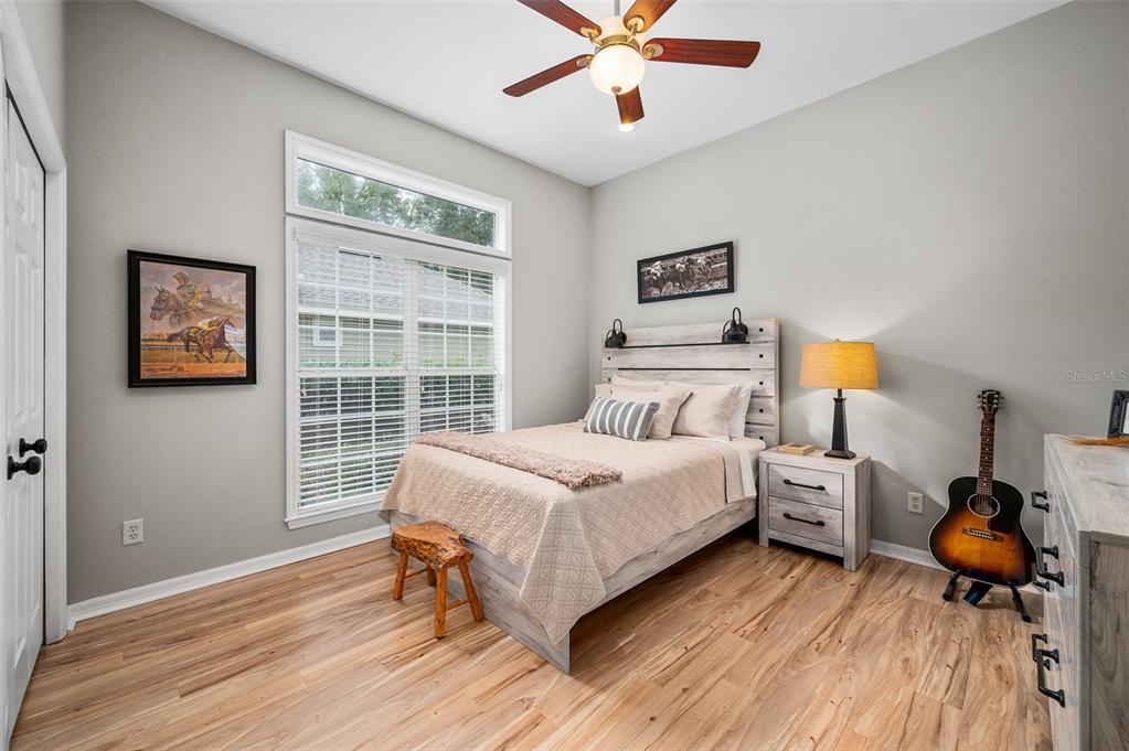 6377 Southwest 88th Terrace Gainesville, FL 32608 - Photo 27 of 37 a bedroom with a bed and wooden floor