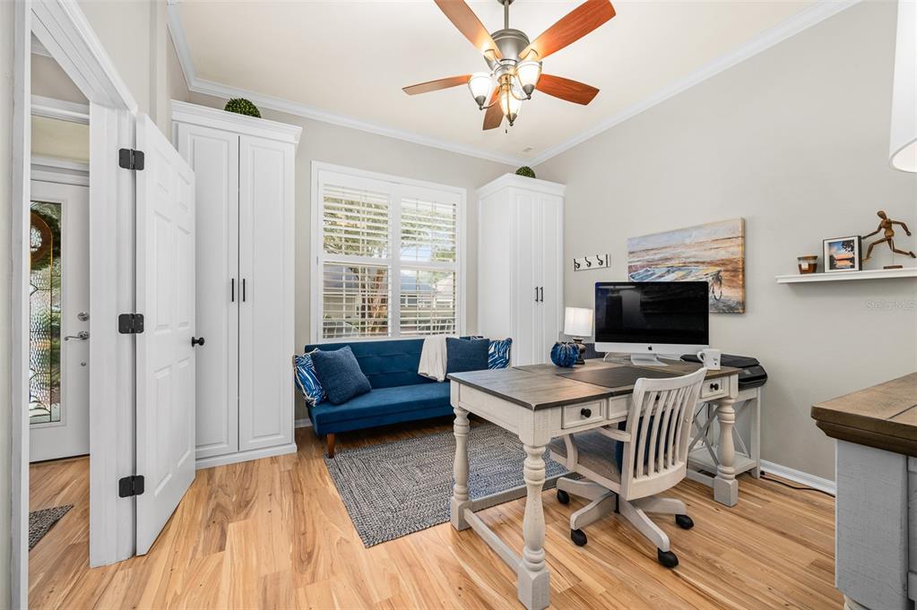 6377 Southwest 88th Terrace Gainesville, FL 32608 - Photo 6 of 37 a workspace with wooden floor and a chandelier fan