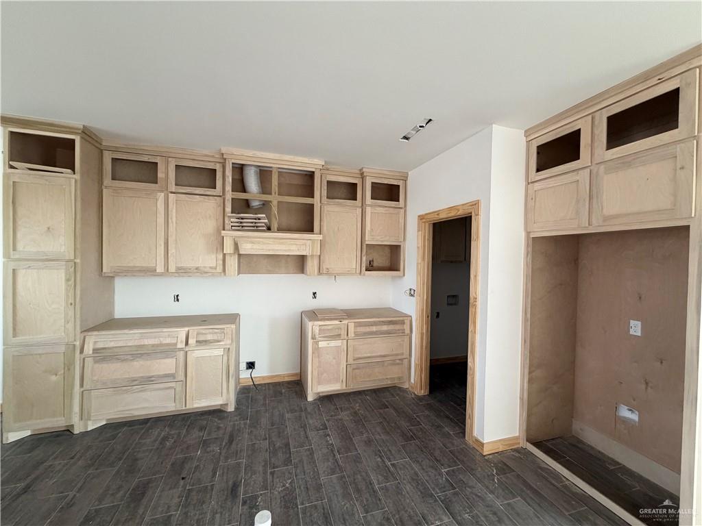 2292 Via Roma Road Weslaco, TX 78596 - Photo 2 of 10 a kitchen with white cabinets and wooden floor