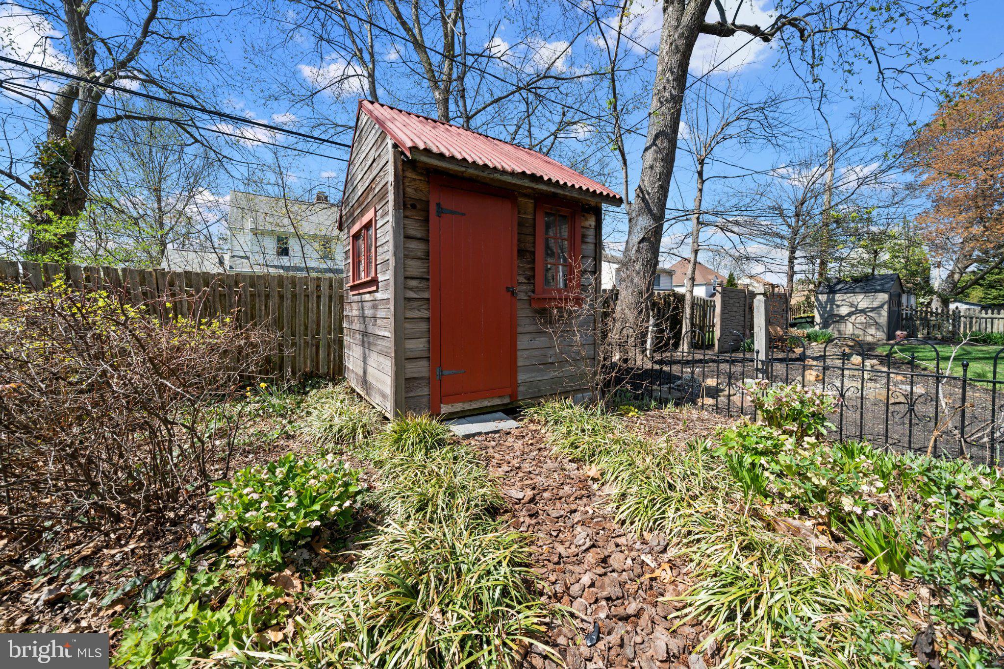 512 Lennox Road Wilmington, DE 19809 - Photo 28 of 28 Charming garden shed in vibrant greenery.