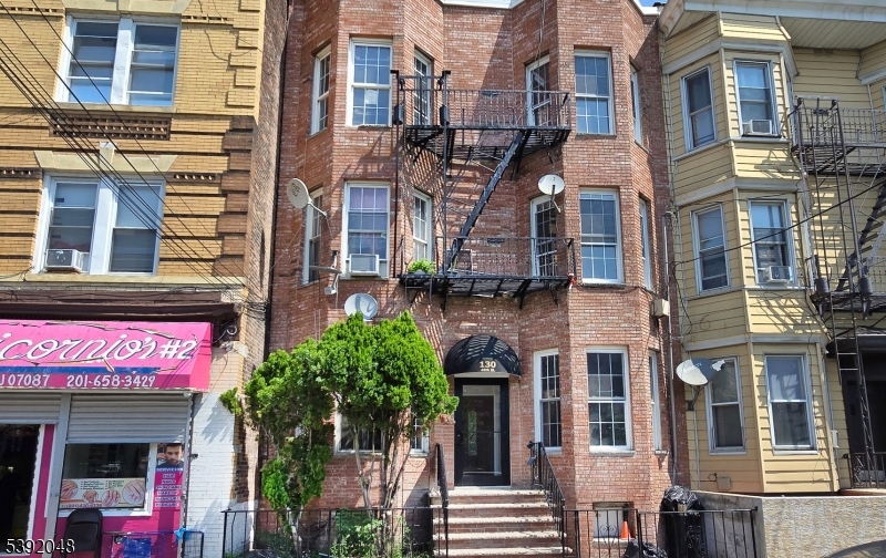 130 45th Street, Unit 2 Union City, NJ 07087 - Photo 3 of 16 a front view of a multi story building with a yard
