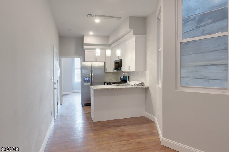 130 45th Street, Unit 2 Union City, NJ 07087 - Photo 5 of 16 a kitchen with a refrigerator and white cabinets