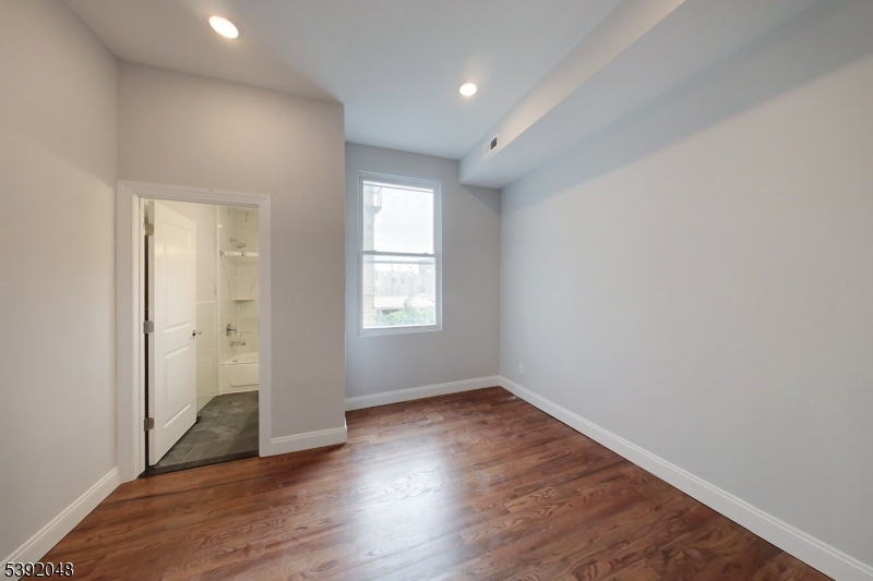 130 45th Street, Unit 2 Union City, NJ 07087 - Photo 10 of 16 an empty room with wooden floor and windows